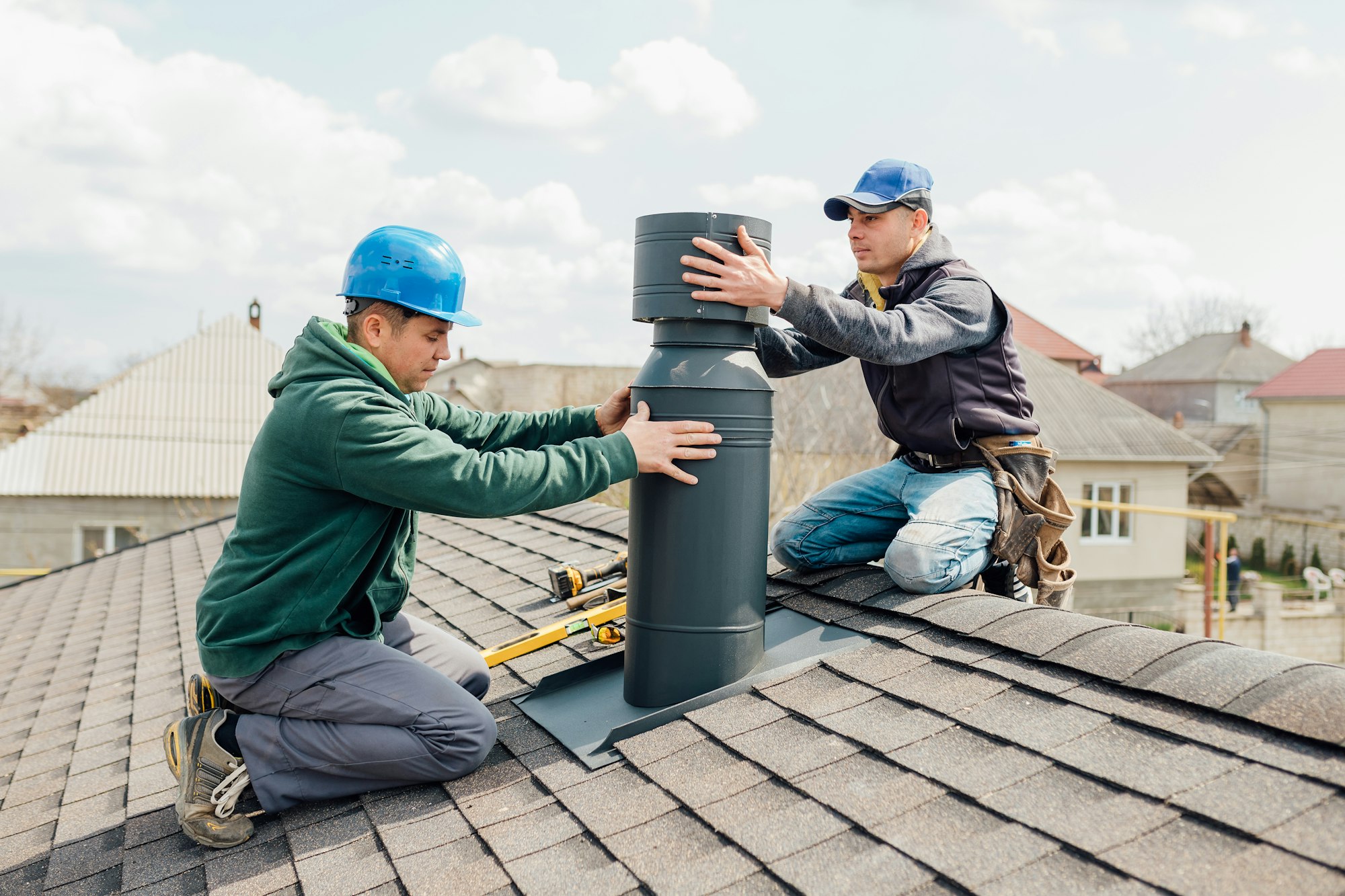 two Professional workmen's standing roof top and measuring chimney